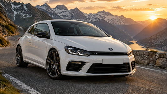 Volkswagen Scirocco R bianca su una strada di montagna al tramonto, vista anteriore di tre quarti