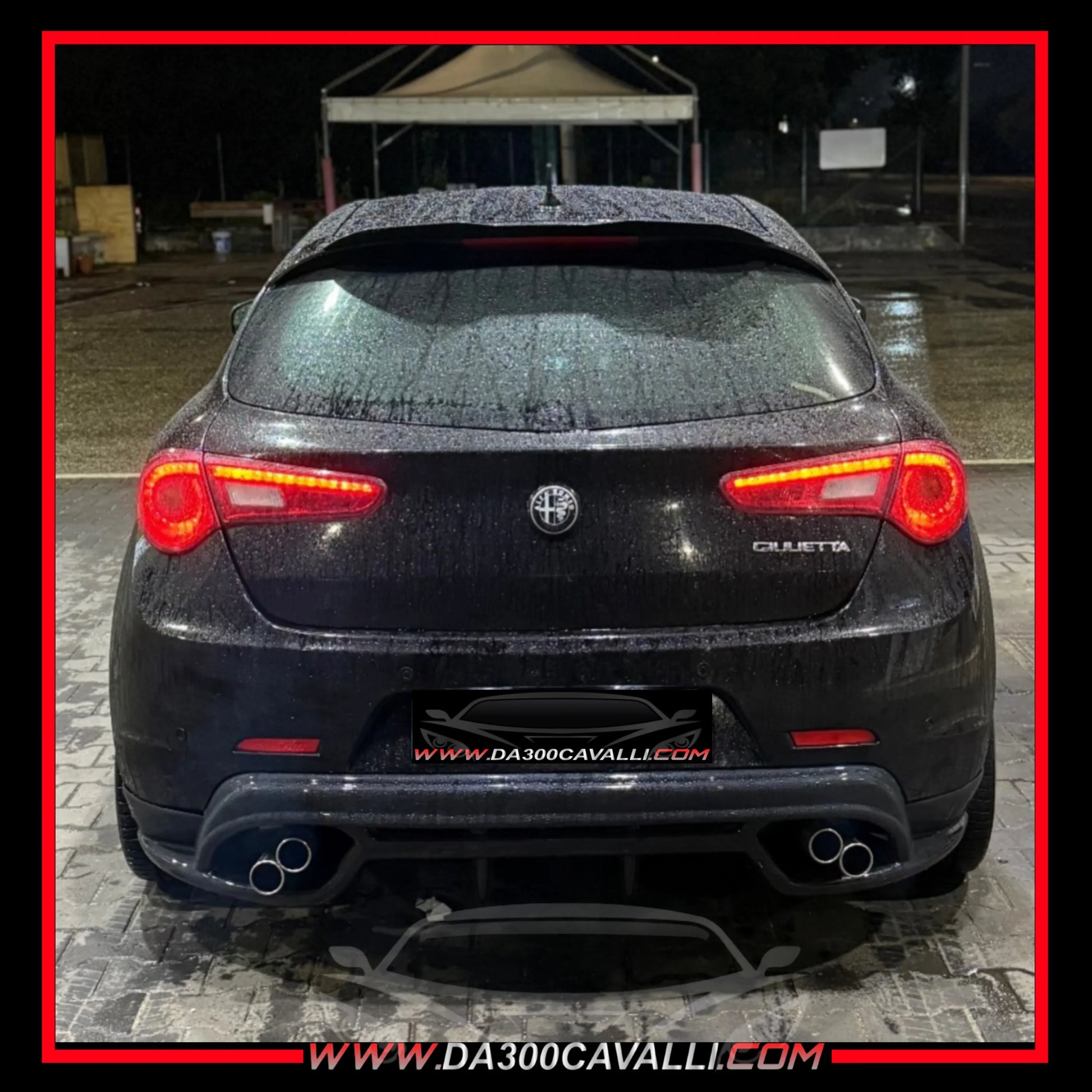 Alfa Romeo Giulietta nera tuning, vista posteriore, targhetta Da300Cavalli, auto bagnata