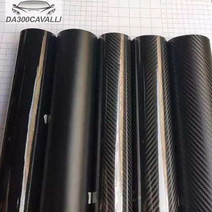 Rotoli pellicola wrap nera e carbonio per auto tuning Da300Cavalli su sfondo a griglia.